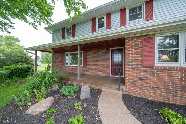 doorway to property featuring a porch and brick siding | Image 5