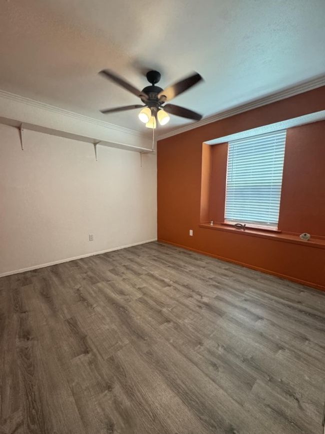 Empty room featuring ornamental molding, ceiling fan, and wood finished floors | Image 7