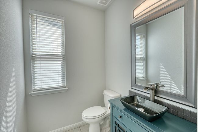 Half bathroom with tile patterned flooring, visible vents, toilet, and vanity | Image 9