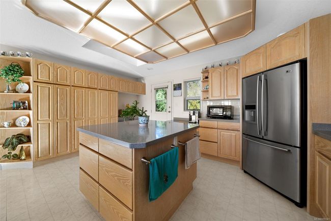 Spacious kitchen features stainless steel appliances, a sizeable island, and a cozy breakfast nook—perfect for gathering and entertaining. | Image 6