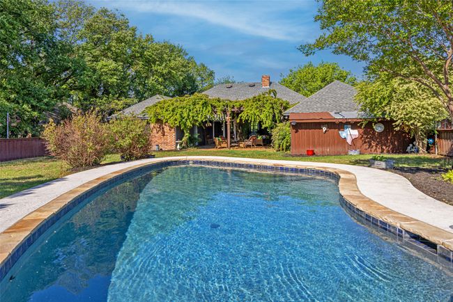 View of pool featuring a fenced in pool, fence, and an outdoor structure | Image 25