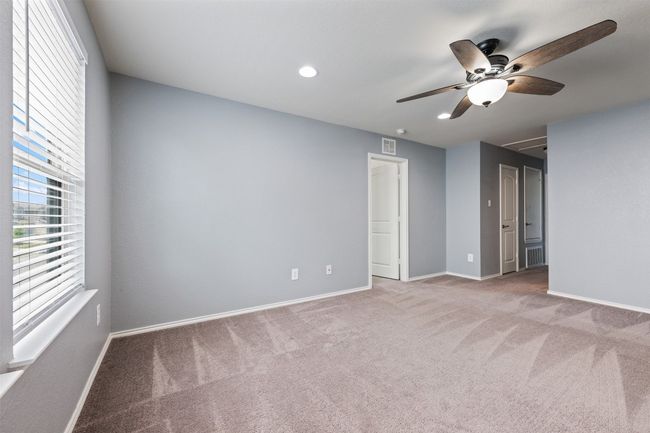 Carpeted empty room featuring baseboards, visible vents, and ceiling fan | Image 25