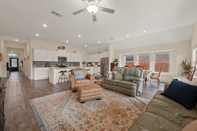 Living area with wood finished floors, lofted ceiling, ceiling fan, and recessed lighting | Image 9