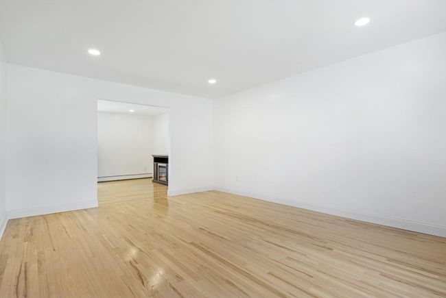 Empty room featuring a baseboard radiator, light wood-type flooring, recessed lighting, and baseboards | Image 7