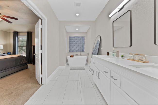 Full bathroom featuring baseboards, connected bathroom, double vanity, ceiling fan, and a soaking tub | Image 34