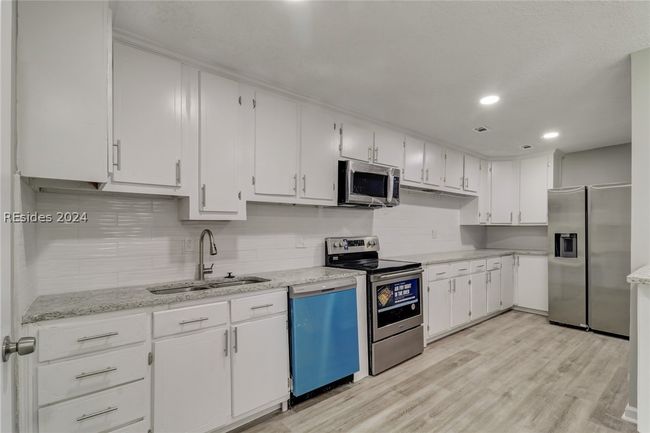 Kitchen featuring tasteful backsplash, sink, appliances with stainless steel finishes, and light wood-type flooring | Image 16