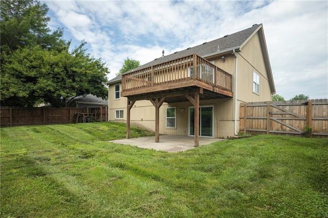 Rear view of house with a patio, a wooden deck, a gate, and a shingled roof | Image 35