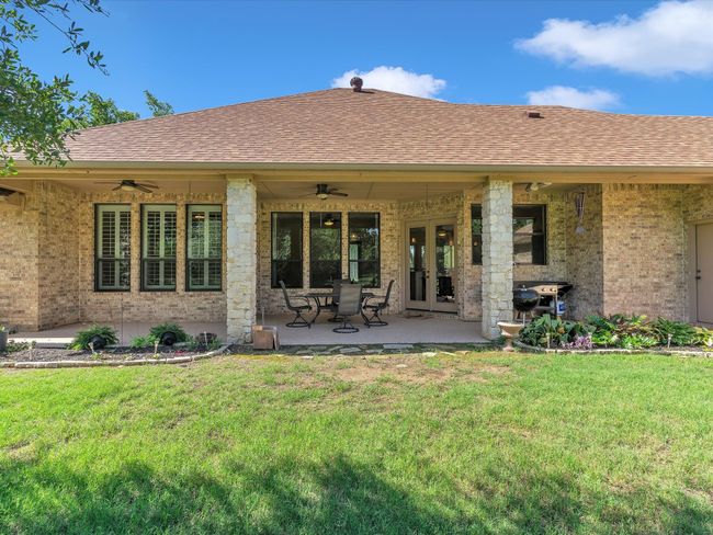 Rear view of house featuring a ceiling fan, french doors, and a yard | Image 33