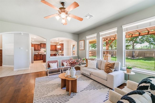 Living room featuring arched walkways, light wood-type flooring, a ceiling fan, and recessed lighting | Image 11