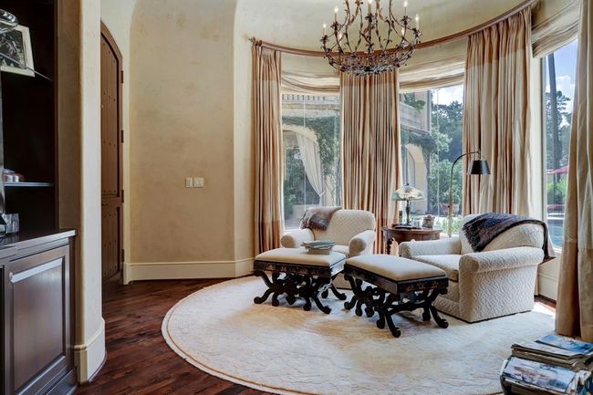 Sitting area off the primary bedroom has chandelier, custom drapes, built in cabinets and walnut floors. | Image 21