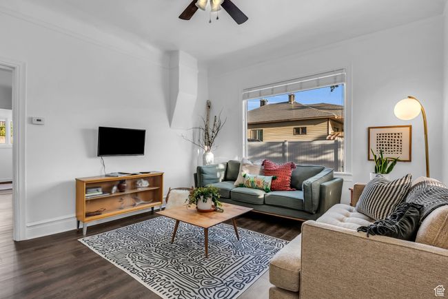 Living area with a ceiling fan, wood finished floors, and baseboards | Image 5