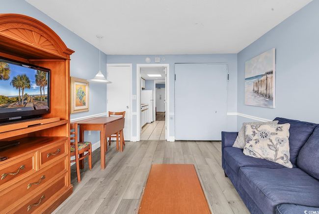 Living area with light wood-style flooring and baseboards | Image 5