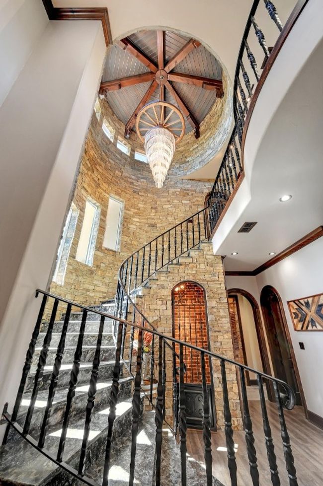 Staircase featuring an inviting chandelier, arched walkways, a towering ceiling, visible vents, and recessed lighting | Image 4