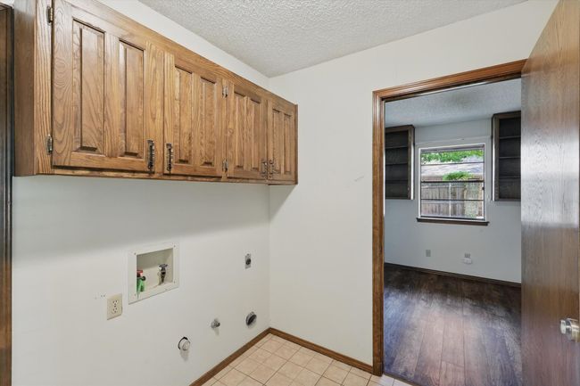 Laundry room featuring a textured ceiling, washer hookup, hookup for a gas dryer, cabinet space, and electric dryer hookup | Image 34