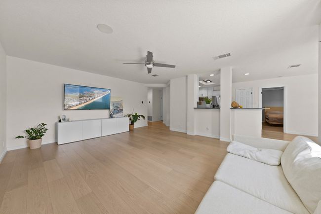 Living area view of entry hall and kitchen featuring ceiling fan, light wood-type flooring, and recessed lighting | Image 4