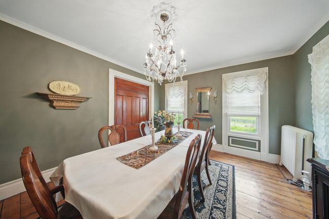 Dining area featuring radiator heating unit, a chandelier, light wood-style flooring, ornamental molding, and baseboards | Image 8