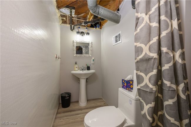 Full bath featuring wood finished floors and a shower with curtain | Image 17