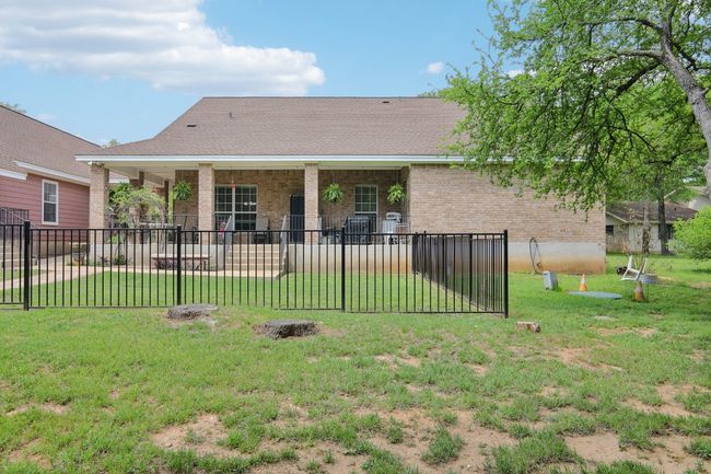 Back of property with brick siding, fence, and a yard | Image 25