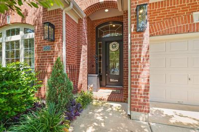 Lush landscaping throughout the front yard, along with shady flowering trees, welcome you home! | Image 2