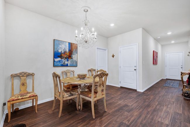 Dining room with baseboards, an inviting chandelier, and dark wood finished floors | Image 8