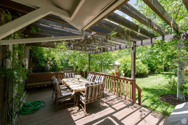 Deck featuring a pergola, outdoor dining space, and a lawn | Image 23