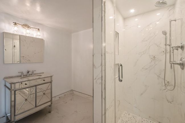 Full bath featuring a marble finish shower, marble finish flooring, and vanity | Image 11