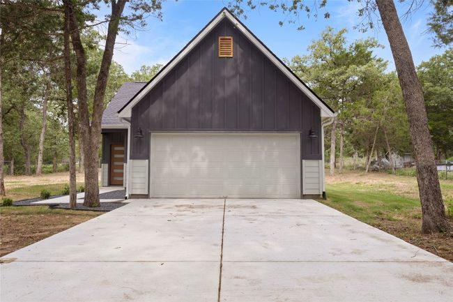 A stunning front view of a beautifully designed home with spacious parking, nestled on nearly an acre of land. | Image 31