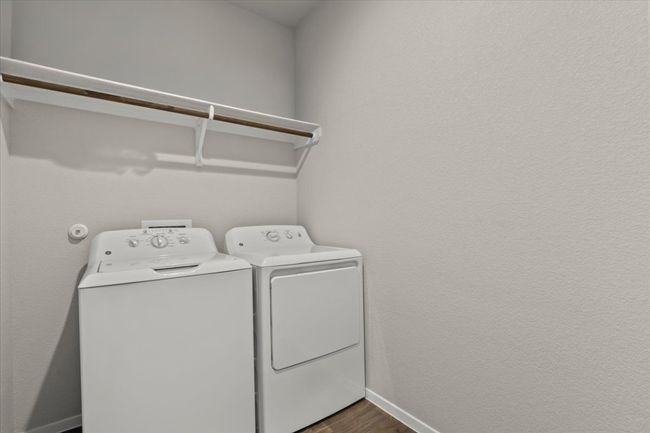 Laundry room featuring washer and dryer, baseboards, and dark wood-type flooring | Image 30