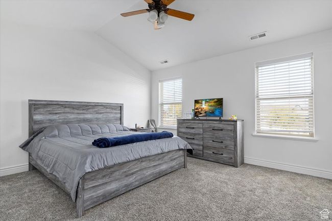 Carpeted bedroom with ceiling fan and lofted ceiling | Image 17