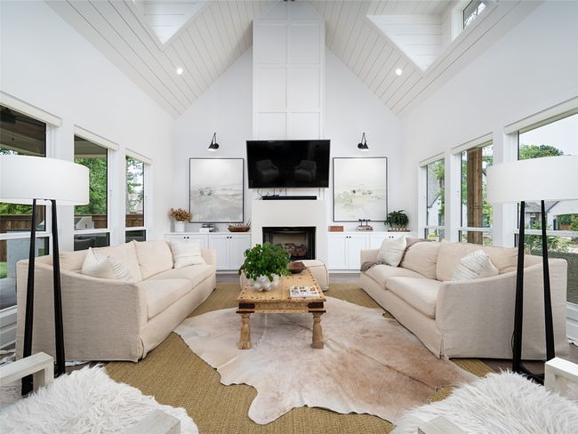 Living room featuring high vaulted ceiling, a skylight, a fireplace, and healthy amount of natural light | Image 7