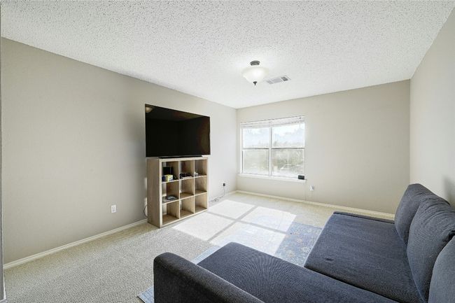 Living room with carpet floors and a textured ceiling | Image 16