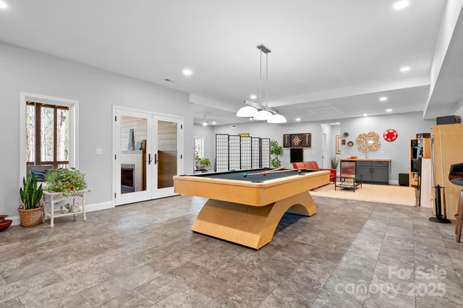 Finished area of the lower level basement with custom pool table that conveys! Many different uses for the space! Use your imagination. Doors to Covered decks overlooking lake. | Image 22