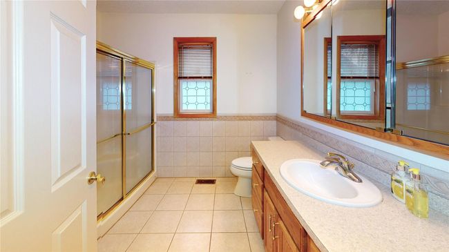Full bathroom with tile patterned flooring, wainscoting, a stall shower, and vanity | Image 15