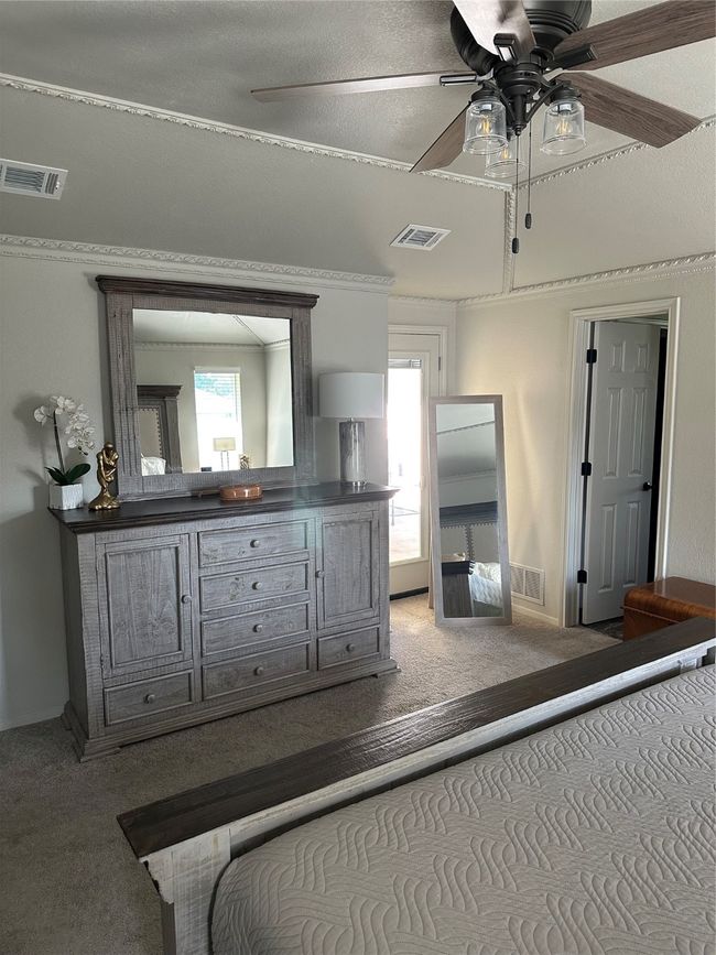 Carpeted bedroom with multiple windows and crown molding | Image 21