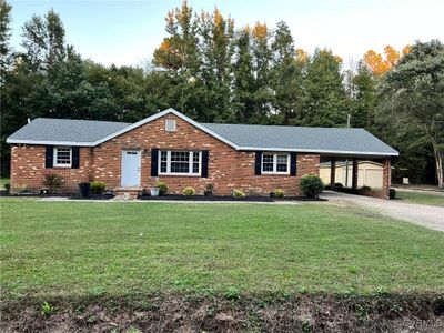 Single story home with a carport and a front lawn | Image 1