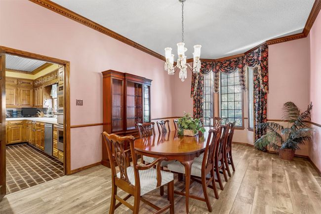 Dining space with light wood-type flooring, ornamental molding, and an inviting chandelier | Image 18