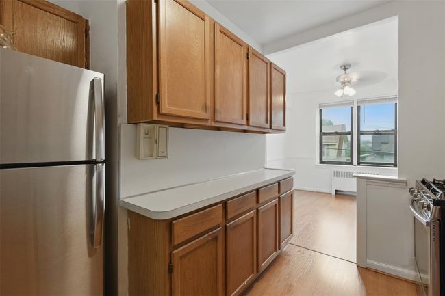 Kitchen with stainless steel appliances, light countertops. | Image 6