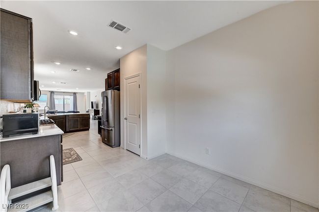 Kitchen featuring high end fridge, dark brown cabinets, light countertops, recessed lighting, and baseboards | Image 17
