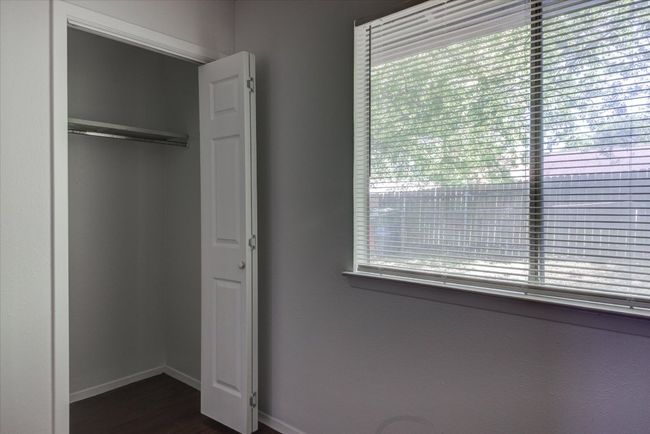 Unfurnished bedroom with dark wood-type flooring and baseboards | Image 13