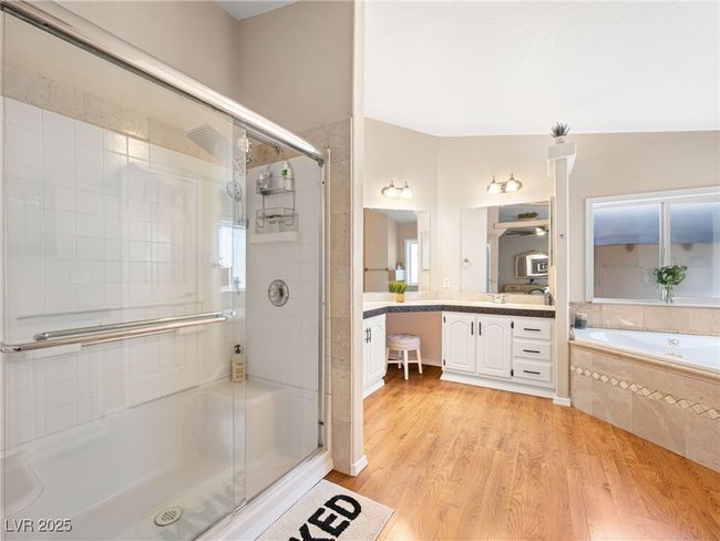 Bathroom with a bath, a stall shower, vanity, and wood finished floors | Image 33