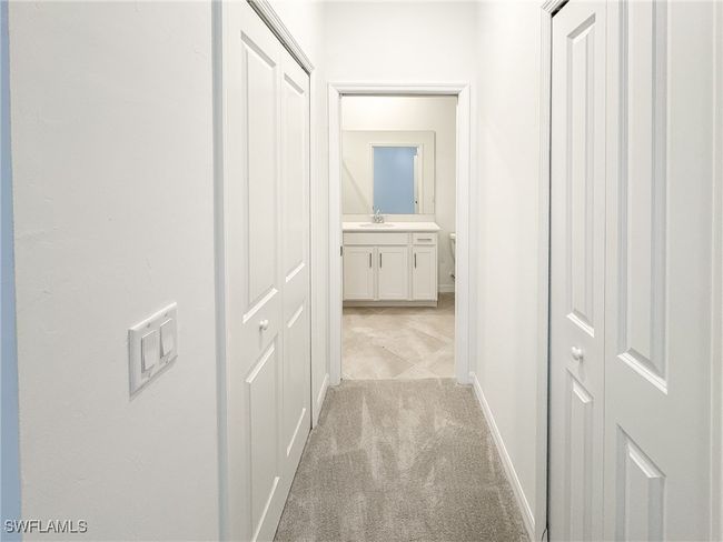 Hall with a sink, light carpet, and baseboards | Image 25