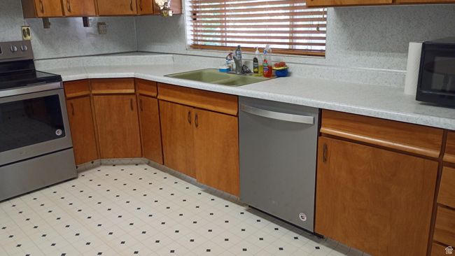 Kitchen with stainless steel appliances, light countertops, and light floors | Image 21