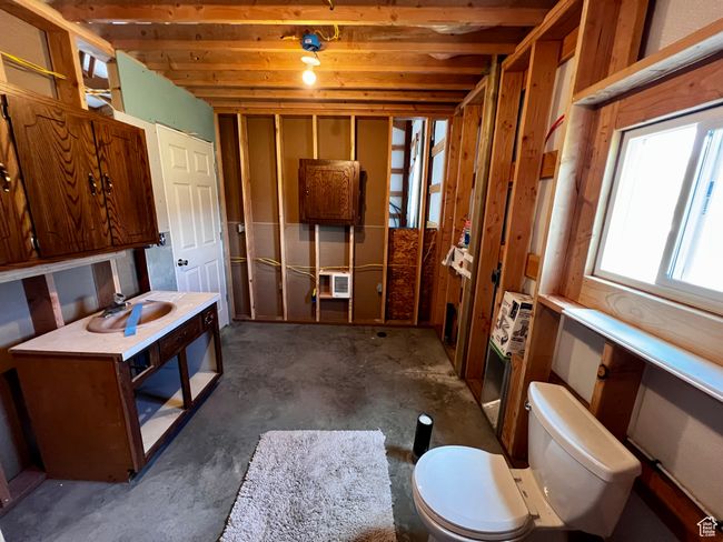 Bathroom with toilet, unfinished concrete flooring, and heating unit | Image 29