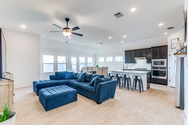 Living area with a ceiling fan, recessed lighting, and light tile patterned floors | Image 5