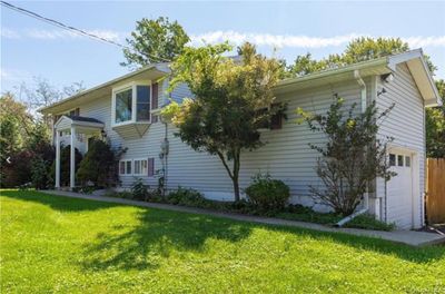 View of side of property featuring a yard and a garage | Image 2