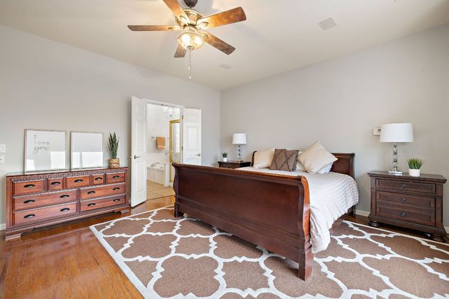 The primary bedroom has beautiful wood floors, a big bay window that overlooks the backyard, and tall ceilings! | Image 10