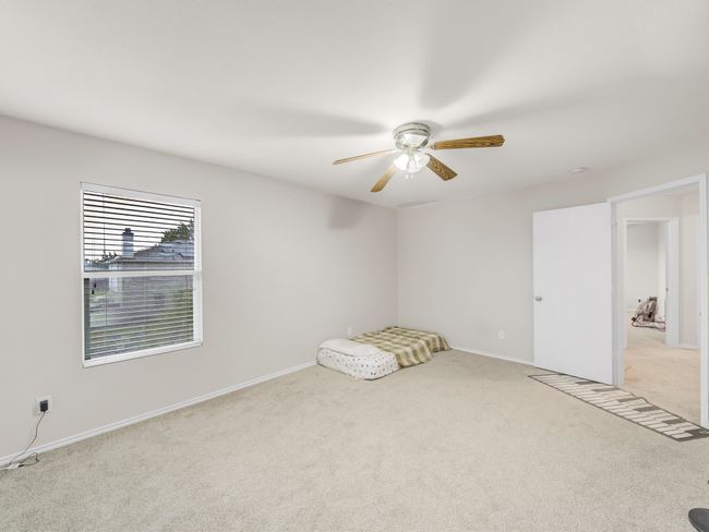 Spare room with light colored carpet, ceiling fan, and baseboards | Image 22