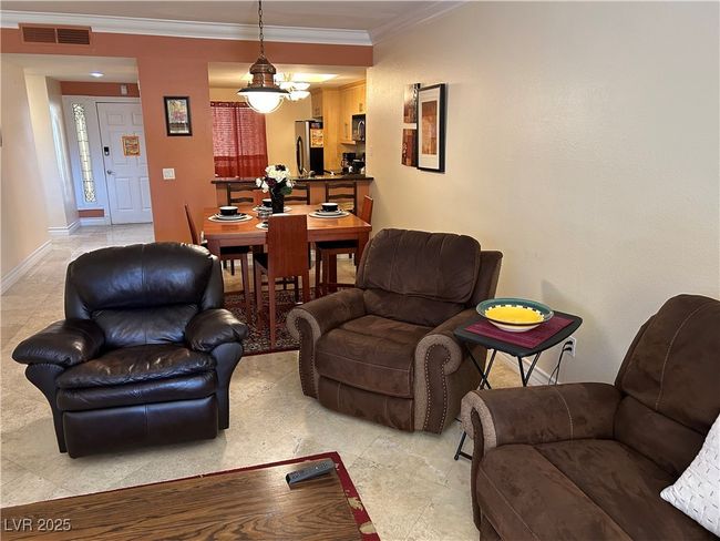 Living room with crown molding and a chandelier | Image 23