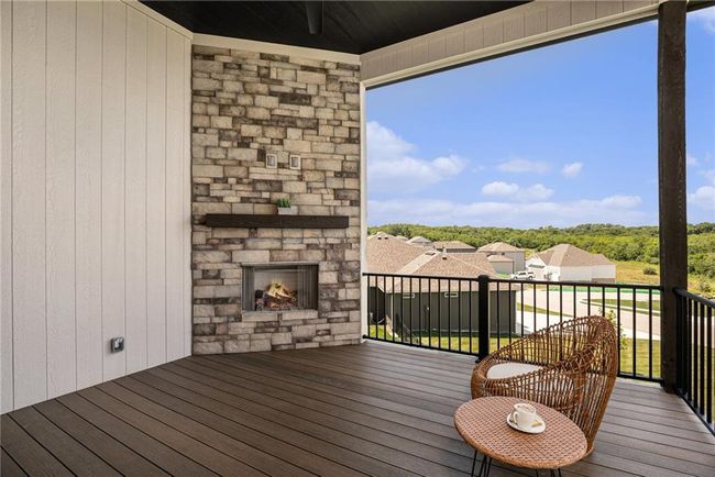 Wooden terrace featuring an outdoor stone fireplace | Image 33