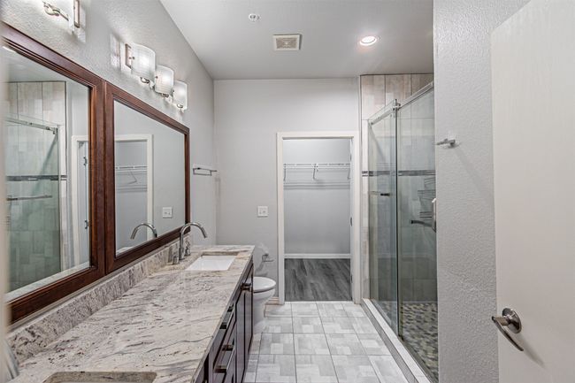 Bathroom featuring double vanity, a spacious closet, a shower stall, and recessed lighting | Image 15